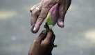 Ein Mann gibt einem Kind, das Lotus-Blüten verkauft, eine Münze. In Bhubaneswar in Indien wird das Hindu-Fest Karthik Purnima gefeiert. Foto: dpa