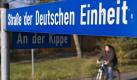 Eine Radfahrerin faehrt am Dienstag (20.10.09) in Regis-Breitingen an dem Strassenschild 'Strasse der Deutschen Einheit ' entlang. Mit nur einer Stimme Mehrheit hat sich die Kleinstadt Regis-Breitingen suedlich von Leipzig 1990 entschieden, die 'Strasse der Einheit' mit dem Einschub 'Deutsche' zu versehen. Ein Vorgehen, das auch heute nicht auf ungeteilte Zustimmung stoesst. 'So ein Kaese', beschwert sich eine der Rentnerinnen ueber das Strassenschild. (zu ddp-Text) Foto: Jens Schlueter/ddp Foto: ddp