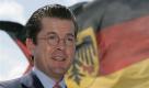 Bundesverteidigungsminister Karl-Theodor zu Guttenberg steht am 28. Juli 2010 im Marinestuetzpunkt in Wilhelmshaven, Niedersachsen, an Bord des Einsatztruppenversorgers Berlin vor einer Deutschlandflagge. Die geplante Strukturreform soll die Bundeswehr nach den Worten von Bundesverteidigungsminister Karl-Theodor zu Guttenberg auch in die Lage versetzen, mehr Soldaten in Auslandseinsaetze schicken zu koennen. In der Bundespressekonferenz aus Anlass des Tages der offenen Tuer der Bundesregierung sagte der Minister am Sonntag, 22. August 2010, die richtige Zielsetzung sei, mit den Zahlen insgesamt runterzugehen und gleichzeitig mehr Soldaten in den Einsatz schicken zu koennen. (apn Photo/Joerg Sarbach)   --- FILE -  Germany's federal defence minister Karl-Theodor zu Guttenberg, is seen in  front a German flag on board the Navy supplier Berlin at the German Naval Base in Wilhelmshaven, on Wednesday, July 28, 2010. (apn Photo/Joerg Sarbach) Foto: ap