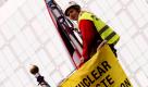 Umweltaktivisten der Organisation Greenpeace halten Plakate hoch, nachdem sie auf Flaggenmaste vor dem europäischen Parlament in Brüssel geklettert sind. Strahlenspezialisten der Organisation brachten vier Samples in zwei Containern zum Eingang des Parlaments. Dutzende von trainierten Aktivisten sperrten die Bereiche ab und fesselten sich selbst an die Container, um deren Sicherheit zu beweisen. Greenpeace protestierte mit der Aktion gegen die Produktion radioaktiven Mülls ohen sichere Endlager zu haben. Foto: dpa
