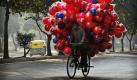 Ein indischer Verkäufer versucht sein schwer beladenes Fahrrad in Neu Dehli zu manövrieren. Foto: ap