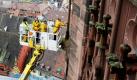 Steinmetze der Freiburger Münsterbauhütte untersuchen am Münster in Freiburg mit einem Hubsteiger die Maßwerke der großen Oktogonfenster und die davor stehenden Dreikantpfeiler auf Steinschäden. Vor zwei Wochen war ein etwa ein Zentner schweres Sandsteinstück aus einem der Fenster gebrochen und auf den Münsterplatz gestürzt. Von diesen Hubsteigern, die maximal 100 Meter in die Höhe gehen können, gibt es deutschlandweit nur zwei Exemplare. Foto: ap