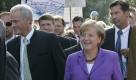 Peter Ramsauer,links, Chef der CSU Landesgruppe und Spitzenkandidat der CSU in Bayern, und Angela Merkel, Bundeskanzlerin und Vorsitzende der Christlich Demokratischen Union (CDU) gehen am Sonntag, 20. September 2009 auf dem Weg zu einer Wahlveranstaltung in Waging, Bayern, an Transparenten protestierender Milchbauern vorbei. Der Kampf um die Waehlerstimmen fuer die Bundestagswahl am 27. September2009 geht in die letzte Phase.(AP Photo/Diether Endlicher) Peter Ramsauer, left, floor leader of the Christian Social Union party and top runner in Bavaria, and German Chancellor Angela Merkel, head of Germany's Christian Democratic Union party(CDU) walk past banners of protesting dairy farmers at an election campaign meeting in Waging, southern Germany, Sunday, Sept. 20, 2009. Germany's federal parliament, the Bundestag, will be elected on Sept. 27, 2009. (AP Photo/Diether Endlicher) Foto: ap