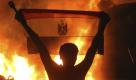 A protester holds the Egyptian national flag as a fire rages outside the building housing the Israeli embassy in Cairo, Egypt, Friday, Sept. 9, 2011. Hundreds of Egyptian protesters, some swinging hammers and others using their bare hands, tore down parts of a graffiti-covered security wall outside the Israeli embassy in Cairo on Friday. Thousands elsewhere protested for the first time in a month against the country's military rulers. (AP Photo) Foto: dapd