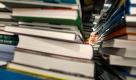 Eine Studentenkrankheit: sich stapelnde Bücher auf dem Schreibtisch. Aber auch der frisch gekaufte oder ausgeliehene Schmöker liegt gerne mal ein Weilchen rum, bis er gelesen wird - weil andere Dinge dazwischenkommen. Foto: dpa