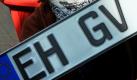 BWL-Studentin Mona Reinke aus Heilbronn hält im City Center in Eisenhüttenstadt ein Autokennzeichen mit der früheren Kennung EH in der Hand. 73 Prozent der Bundesbürger haben sich bei einer Befragung der Hochschule Heilbronn für eine Rückkehr zu früheren Nummernschildern ausgesprochen.  Foto: dpa
