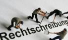 Modelleisenbahnfiguren machen sich an dem Wort «Rechtschreibung» zu schaffen. Foto: Frank Rumpenhorst Foto: dpa