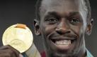 Breiter kann ein Lächeln kaum sein: Usain Bolt freut sich über seine Goldmedaille. Foto: dpa