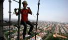 Jakarta, Indonesien. Ein Arbeiter sitzt auf einem Stahlgerüst in schwindelerregender Höhe und befestigt ein Seil am Gerüst. Foto: dapd