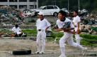 Inmitten der Trümmerlandschaft der japanischen Hafenstadt Minamisanriku spielt der dreizehnjährige Shin Yamauchi (Zweiter von rechts) mit seinen Teamkameraden Baseball. Die japanischen Behörden melden, dass nach dem verheerenden Tsunami Anfang März immer noch ungefähr 8300 Menschen vermisst werden. Foto: dpa
