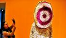 Eine Journalistin fotografiert im Kunstmuseum in Wolfsburg das Werk Klang-Anzug von Nick Cave aus dem Jahr 2010. Die Ausstellung Art  Fashion - zwischen Haut und Kleid ist von Samstag bis zum 07. August 2011 im Kunstmuseum zu sehen. Als Highlight ist Ende März ein Fashion-Weekend mit einigen Modeschauen geplant. Foto: dpa