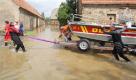 Helfer der Deutschen Lebens-Rettungs-Gesellschaft e.V. (DLRG) schieben ein Boot im Hochwasser der Neiße in Ostritz. Foto: ap