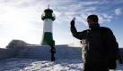 Ein Tourist fotografiert in Sassnitz auf Rügen den Leuchtturm und die vereiste Mole. Bei Dauerfrost mit zweistelligen Minusgraden wächst die Eisschicht auf den Küstengewässern entlang der Ostsee.  Foto: ddp