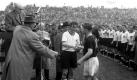 Fast etwas verlegen nimmt Fritz Walter die Glückwünsche des ungarischen Spielführers Ferenc Puskas entgegen. Die DFB-Elf hat ordnungsgemäß Aufstellung genommen und beobachtet die Szenerie andächtig.
 Foto: dpa