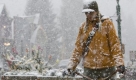 Ali Fuchs of Crested Butte, Colo. walks her dog Bella during a snow fall on Monday, Sept. 21, 2009. The last day of summer brought light snow, chilly temperatures and freeze warnings across Colorado. (AP Photo/Nathan Bilow) Foto: ap