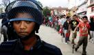 Skeptischer Seitenblick  Sicherheitsbeamte behalten den Protestzug der Vereinigten Maoisten in der nepalesischen Hauptstadt Kathmandu im Auge. Foto: dpa