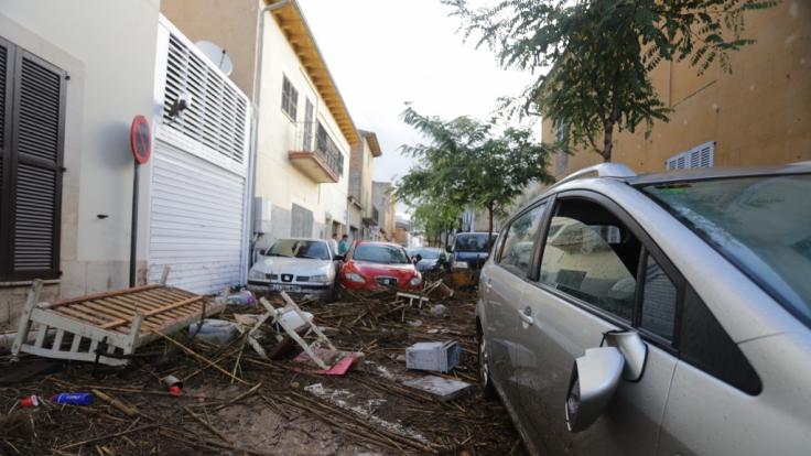 Sant Llorenç des Cardassar: Trümmer und Autos stehen auf einer von Starkregen verwüsteten Straße.
