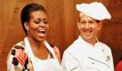 Steaks legt die amerikanische First Lady Michelle Obama auf der Ramstein Airbase in Rheinland-Pfalz auf den Teller eines Soldaten. Ausgestattet mit Schürze, Handschuhen und Servierzange fand die Frau des US-Präsidenten Barack Obama für jeden der Hungrigen noch ein paar persönliche Worte.  Foto: dpa