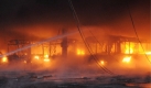 Ein Feuerwehrmann versucht, in der Nacht einen Brand einer Halle im Depot des Busunternehmens HEAG in Darmstadt zu löschen. Bei dem Brand im Depot des Darmstädter Busunternehmens sind 40 bis 50 Busse beschädigt worden. Foto: ddp
