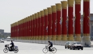 In Peking laufen die Vorbereitungen für die Parade zum 60. Nationalfeiertag. Hier fährt einRadler an riesigen Säulen vorbei, die Chinas ethnische Vielfalt repräsentieren sollen. Foto: ap