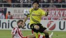Olympiakos' Olof Melberg, left, tries to stop Borussia Dortmund's Shiji Kagawa during their Champions League Group F soccer match in the port of Piraeus, near Athens, on Wednesday, Oct. 19, 2011.  (AP Photo/Thanassis Stavrakis) Foto: dapd