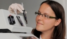 Die Laborantin Melanie Trenkmann hält in der Analytik Jena AG eine Kartusche mit Detektionseinheit eines bioanalytischen Komplettsystems zum Nachweis des H1N1 Virus. Foto: ap