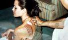 US-Schauspielerin Angelina Jolie (l) lässt sich im thailändischen Pathumthani von Tattoo-Meister Noo Kampai ihre linke Schulter mit alten Schriftzeichen der Khmer verzieren lassen (Archivbild vom 24.04.2003). Nach Aussage des Tätowiereres sollen die schwarzen fünfreihigen Schriftzeichen Pech fernhalten und vor Unfällen schützen. Die Zahl der Tattoo-Träger in Deutschland hat sich nach einer Umfrage des Meinungsforschungsinstituts polis im Auftrag der Deutschen Presse-Agentur (dpa) in den vergangenen Jahren verdoppelt. dpa (Zu polis-Umfrage im Auftrag der dpa) Foto: dpa