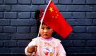 Ein kleines Mädchen hält eine Chinesische Flagge in Peking hoch. Foto: ap