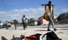 Somalische Soldaten laufen an einem Leichnam in  Mogadischu vorbei. Der Tote wollte eine Bombe installieren, die jedoch frühzeitig explodierte. Foto: ap