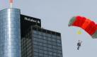 Ein Base-Jumper gleitet in Frankfurt am Main vor der Zentrale der Landesbank Hessen-Thüringen (Helaba) in die Tiefe. Foto: Arne Dedert/Archiv Foto: dpa