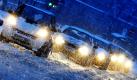 Über eine schneebedeckte Fahrbahn fahren Autos durch das Schneetreiben in München. Heftige Schneefälle in Verbindung mit einem stürmischen Wind führen in Bayern zu erheblichen Verkehrsbehinderungen. Foto: dpa