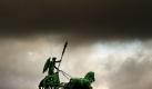 Die Quadriga auf dem Brandenburger Tor in Berlin zeichnet sich vor fast schwarzem Himmel ab. Das Wetter ist typisch für den April: wechselhaft, mit vereinzelten Regenschauern und sonnigen Abschnitten. Für die kommenden Tage haben die Meteorologen jedoch mehr Sonnenschein vorausgesagt. Foto: dpa