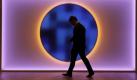 Ein Teilnehmer der UN Klimakonferenz läuft vor einer Lichtinstallation im Bella Zentrum in Kopenhagen. Foto: ap