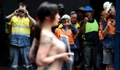 Bauarbeiter fotografieren eine nackte Demonstrantin der Tierschutzorganisation Peta in Sidney. 
 Foto: dpa