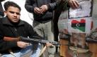 Ein Libyer hält die Waffe auf ein Poster von Machthaber Muammar al-Gaddafi. Die Proteste in dem nordafrikanischen Land gehen weiter. Foto: dpa