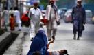 Eine afghanische Frau bettelt in einer Straße in Jalalabad um Almosen, während ihre Tochter auf dem Fußweg schläft. Foto: ap