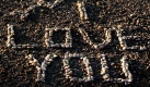 Ein Pärchen geht an der selbst entworfenen Aufschrift Ich liebe dich am Strand von Nizza entlang. Foto: ap