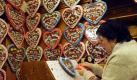 Margarete Hollmann fertigt in der Herzlmacher-Bude auf dem Bremer Freimarkt Lebkuchenherzen direkt nach Vorgabe der Kunden. Das größte und älteste Volksfest in Norddeutschland findet in diesem Jahr zum 975. Mal in Bremen statt.  Foto: dpa