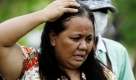 Eine philippinische Frau ist entsetzt, als sie die Leichen an einem Hang in Ampatuan, einer Provinz im Süden der Philippinen sieht. Mehr als 100 Bewaffnete hatten am Montag den Autokonvoi eines Gouverneurskandidaten überfallen und seine Anhänger sowie begleitende Lokaljournalisten brutal ermordet. Foto: ap