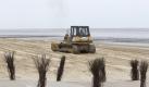 Am Strand von Cuxhaven - Duhnen verteilt eine Planierraupe frisch aufgeschütteten Sand. Auf dem sechs Kilometer langen Strandabschnitt werden rund 10.000 Kubikmeter Sand verteilt, bevor die Strandkörbe wieder aufgestellt werden. Die Saison startet Mitte April mit den Osterferien.
 Foto: dapd