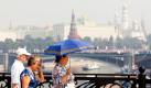 Russische Passanten laufen im Zentrum Moskaus über eine Brücke. Die Stadt ächzt derzeit unter Temperaturen über 35 Grad und dem damit verbundenen Smog, der wie eine Glaskuppel über der russischen Hauptstadt liegt. Foto: dpa