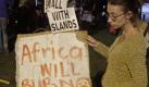 Protesters hold a night vigil as talks at the climate change summit stall in Durban, South Africa, Friday, Dec 9, 2011. Negotiators from Europe, small islands threatened by rising oceans and the world's poorest countries sought to keep alive the only treaty governing global warming and to move on to the next stage, struggling against an unlikely alliance of the United States, China and India. Poster reads: Africa will burn. (AP Photo/Schalk van Zuydam) Foto: dapd