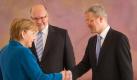 Bundeskanzlerin Merkel schüttelt dem scheidenden Umweltminister Röttgen (r) die Hand. Dahinter dessen Nachfolger Peter Altmaier. Foto: Michael Kappeler Foto: dpa