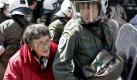 Sicheres Geleit: Eine ältere Dame wird am griechischen Unabhängigkeitstag in Sicherheit gebracht. Bei einer Parade war es zu Auseinendersetzungen zwischen Polizisten und Demonstranten gekommen. Foto: Alkis Konstantinidis Foto: dpa