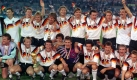 Das Archivbild vom 08.07.1990 zeigt die deutsche Nationalmannschaft, die sich nach dem 1:0-Finalsieg gegen Argentinien bei der Fußball-Weltmeisterschaft im Olympiastadion von Rom zum Mannschaftsfoto aufstellt: Stehend (v.l.): Klaus Augenthaler, Stefan Reuter, Jürgen Klinsmann, Frank Mill, Guido Buchwald, Paul Steiner, Thomas Berthold, Andreas Köpke und Jürgen Kohler; Hockend (v.l.): Torwart-Trainer Sepp Maier, Andreas Brehme, Lothar Matthäus (mit dem WM-Pokal), Karlheinz Riedle, Bodo Illgner, Uwe Bein, Günter Hermann, Rudi Völler und Thomas Häßler. Deutschland wird nach 1954 und 1974 zum dritten Mal Weltmeister. dpa (zu dpa-Themenpaket: '100 Jahre DFB' vom 21.01.2000) Foto: dpa