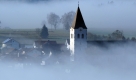 Der Turm der Pfarrkirche St. Nikolaus ragt in Hunderdorf in Niederbayern aus dem Nebel. Laut Vorhersage der Meteorologen wird das Wetter in Bayern in den kommenden Tagen nach Auflösung einzelner Nebelfelder meist sonnig. Foto: dpa