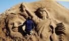 Ein Künstler arbeitet am Strand von Busan in Südkorea an einer Sandversion der amerikanischen Freiheitsstatue und des früheren US-Präsidenten Abraham Lincoln. Foto: ap