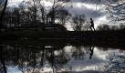 Spieglein, Spieglein an der Wand: Ein Jogger spiegelt sich auf einer Wasseroberfläche im Englischen Garten in München . Foto: Peter Kneffel Foto: dpa