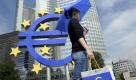 Eine junge Frau mit Euro-Schirm und Tuete geht am Dienstag (16.08.11) in einer gestellten Szene vor der Europaeischen Zentralbank (EZB) in Frankfurt am Main. Der Streit um die moegliche Einfuehrung von Euro-Bonds wird jetzt auch in der hessischen Landespolitik ausgefochten. Ministerpraesident Volker Bouffier (CDU) sprach sich am Montagabend (15.08.11) im Radiosender HR info gegen solche gemeinsamen Staatsanleihen der Euro-Laender aus. Dagegen verlangten fuehrende Vertreter von SPD, Gruenen und Linken am Dienstag einhellig Euro-Bonds zur Stabilisierung der europaeischen Waehrung. Foto: Thomas Lohnes/dapd Foto: dapd
