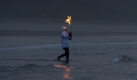 Der Surfer Ruth Sadler, 72, mit der OlympischenFackel im Pacific Rim National Park im kanadischen Tofino. Foto: ap